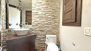 Half bathroom with vanity and a chandelier