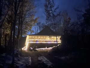 Property exterior at twilight featuring a gazebo and a wooden deck