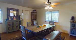 Dining room with dark wood-type flooring and a ceiling fan