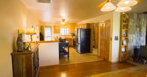 Kitchen featuring freestanding refrigerator, light wood finished floors, and ceiling fan