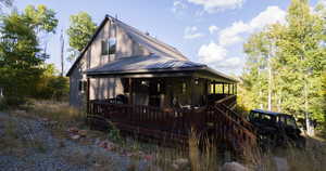 Rear view of house featuring a metal roof and a deck