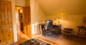 Office/Guest Room featuring vaulted ceiling and light wood-type flooring