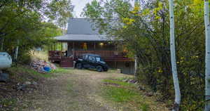 Rear view of house featuring a wooden deck and a metal roof