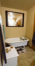 Full bath with a freestanding tub and light tile patterned flooring