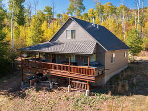 Rear view of property featuring a metal roof and a wooded view
