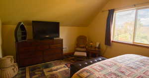 Bedroom with vaulted ceiling and baseboards