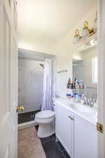 Full bath featuring vanity, a shower stall, dark tile patterned flooring, and a textured ceiling