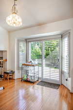 Doorway to outside featuring hardwood / wood-style floors and baseboards