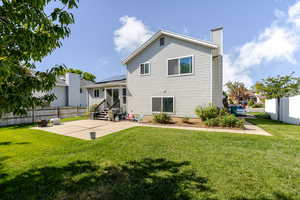 Back of property with a patio area, a chimney, entry steps, and roof mounted solar panels