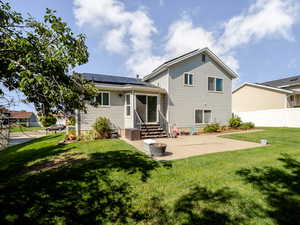 Back of property featuring a patio area, solar panels, and entry steps