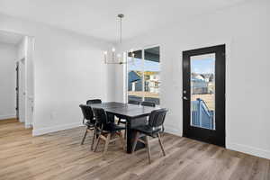Dining area with light wood finished floors and a chandelier