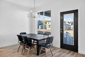 Dining area with light wood-type flooring and a chandelier