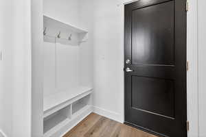Mudroom featuring light wood-style floors and baseboards