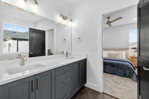 Bathroom featuring double vanity, ensuite bath, dark carpet, and a ceiling fan