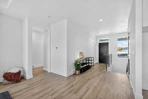 Living room with light wood-style floors and recessed lighting
