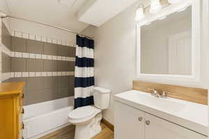 Bathroom featuring vanity, shower / bath combination with curtain, and light wood-style flooring