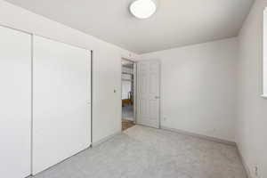 Unfurnished bedroom with carpet and a closet