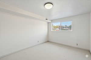 Carpeted empty room featuring baseboards