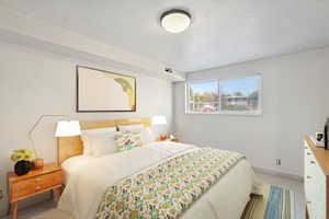 AI created image of fully furnished Carpeted bedroom with baseboards and a textured ceiling