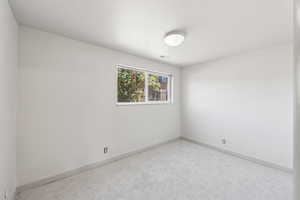 Unfurnished room featuring baseboards and carpet