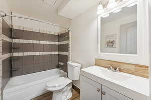 Full bath featuring shower / bathtub combination, vanity, and wood finished floors