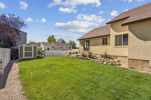 Side Yard with Shed, Water Feature, and Lush Grass, Lot Partially Fenced