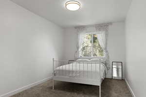 Carpeted bedroom with baseboards and a textured ceiling