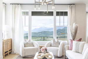 Sitting room with plenty of natural light, a mountain view, and wood finished floors