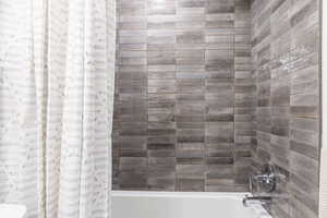 Bathroom with shower / bath combination with curtain