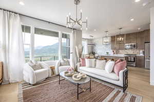 Living room with a chandelier, recessed lighting, light wood finished floors, and a mountain view