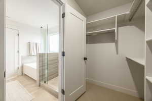 Walk in closet with light tile patterned flooring