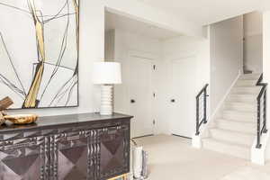 Entryway featuring stairway and light colored carpet