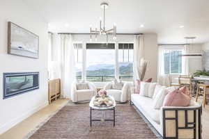 Living room featuring a chandelier, light wood-type flooring, a mountain view, and recessed lighting