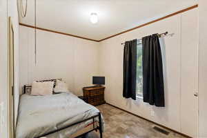 Bedroom featuring ornamental molding and stone finish floors