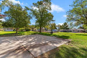 View of home's community with a lawn and community basketball court