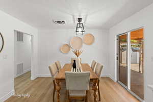 Dining room featuring a textured ceiling and light wood-type flooring