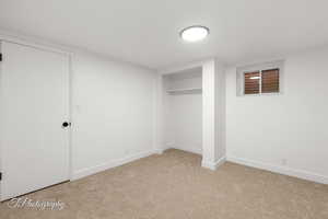 Finished basement with baseboards and light carpet