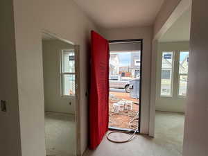 Doorway to outside with unfinished concrete floors