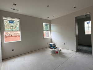 Unfurnished room featuring plenty of natural light and concrete flooring