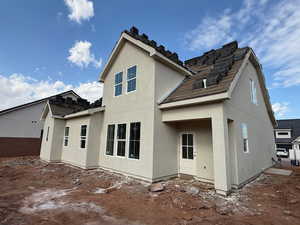 Back of property with stucco siding and a patio area