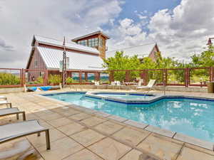 Community pool with a community hot tub and a patio