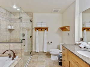 Full bathroom with vanity, a bath, a shower stall, and light tile patterned floors