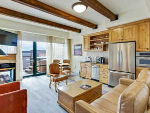 Living room featuring beam ceiling and baseboards