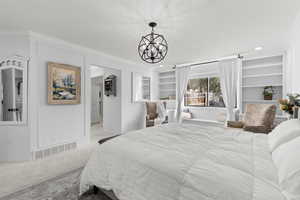 Carpeted bedroom with crown molding, a chandelier, and recessed lighting