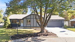 View of front facade with a shingled roof, concrete driveway, and an attached garage