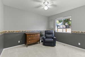 Living area featuring carpet flooring and ceiling fan