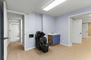 Misc room with light wood finished floors and a textured ceiling