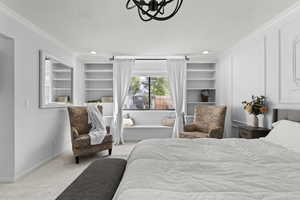Carpeted bedroom with ornamental molding and a textured ceiling