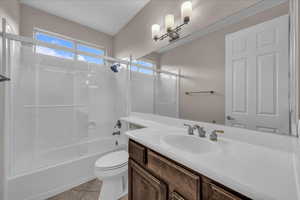 Bathroom with enclosed tub / shower combo, vanity, and light tile patterned floors
