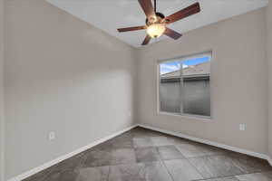 Unfurnished room featuring baseboards and a ceiling fan